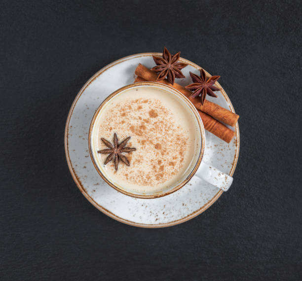 Masala chai tea on a dark background closeup. Traditional Indian hot drink with milk and spices. Top view, flat lay. Masala chai tea on a dark background close up. Traditional Indian hot drink with milk and spices. Top view, flat lay. chai stock pictures, royalty-free photos & images