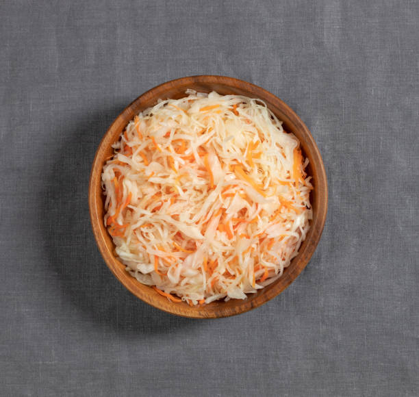 sauerkraut in a wooden bowl on a gray background close up. fermented food. cabbage salad with carrots. top view, flat lay. - bigos imagens e fotografias de stock