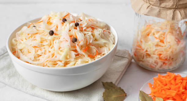 Sauerkraut in a bowl closeup. Fermented food. Cabbage salad with carrots. Healthy vitamin food. Sauerkraut in a bowl close up. Fermented food. Cabbage salad with carrots. Healthy vitamin food. side dish stock pictures, royalty-free photos & images