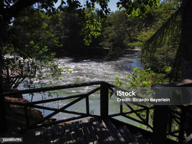 Paraiba Do Sul River In The City Of Guararema With Its Waters Covered By Silvery Reflections Framed By Vegetation And A Shaded Wooden Deck Stock Photo - Download Image Now