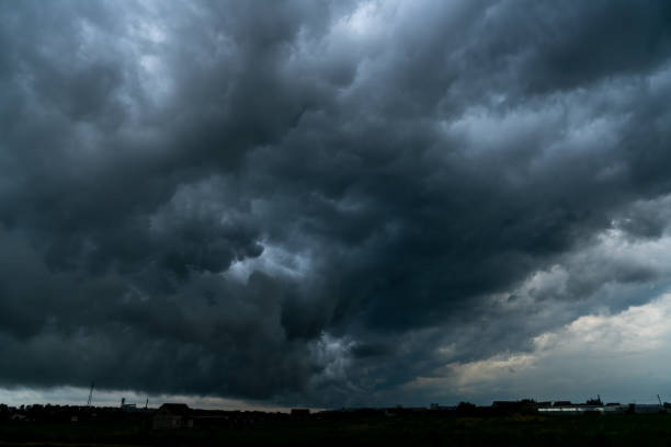 drammatico cielo tempestoso con sottile linea d'orizzonte. temporale sul campo. - storm cloud dramatic sky cloud cumulonimbus foto e immagini stock