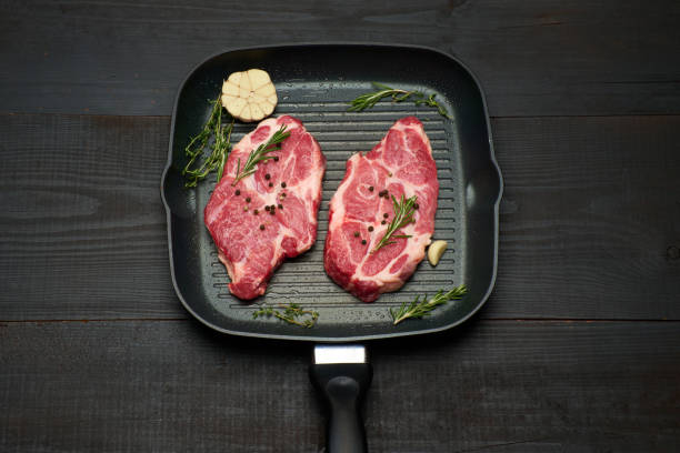 istock Fresh raw beef or pork steaks on frying pan 1330808039