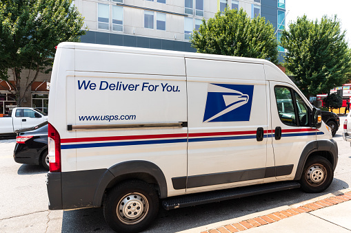 Asheville, NC, USA-22 July 2021: Image of a white Dodge Ram Postal delivery van, at curbside.  Lettering-\
