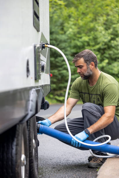 istock Man Emptying RV Sewer at Dump Station After Camping 1330814223