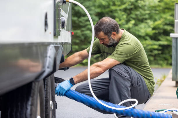 istock Man Emptying RV Sewer at Dump Station After Camping 1330814968