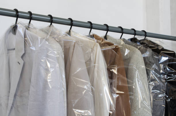 Rack with clean coats after dry cleaning on a dry cleaner. Quality laundry service. Hangers row. Winter season. Rack with clean coats after dry cleaning on a dry cleaner. Quality laundry service. Hangers row. Winter season. dry cleaner stock pictures, royalty-free photos & images