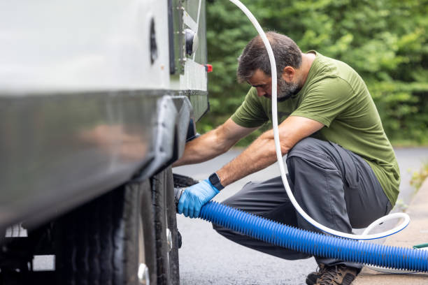 istock Man Emptying RV Sewer at Dump Station After Camping 1330815565