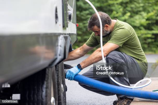 Man Emptying Rv Sewer At Dump Station After Camping Stock Photo - Download Image Now
