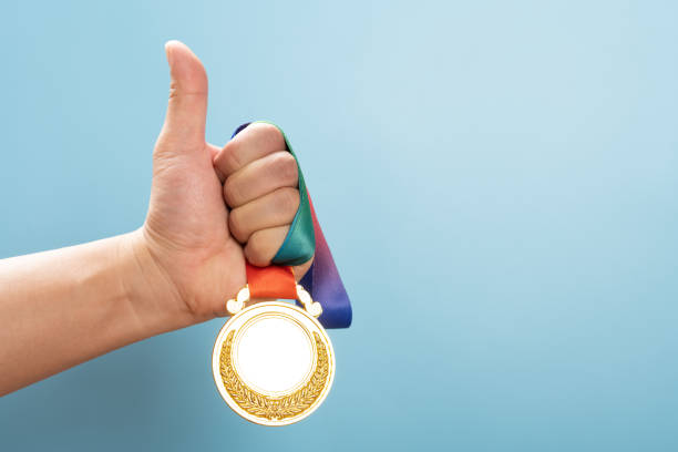 istock man lifting a gold medal with the thumb up 1330823419