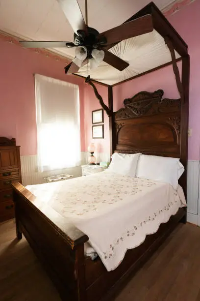 Antique canopy bed in a pink guestroom at T'Frere's B&B, a Cajun 1880 Acadian colonial home made of red cypress, Lafayette, Louisiana, USA