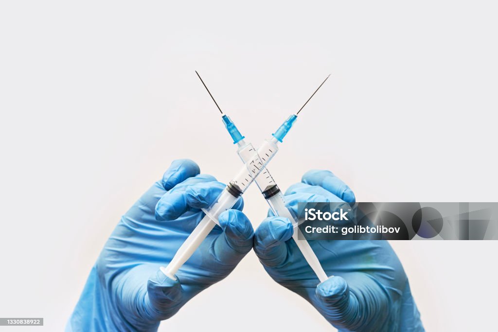 Anti vaccine or anti vaxxer compaign concept Anti vaccine or anti-vaxxer campaign concept. Symbol of anti-vaccination movement. Doctor hand crossing syringes over white background. Anti-vaccination propaganda Vaccination Stock Photo
