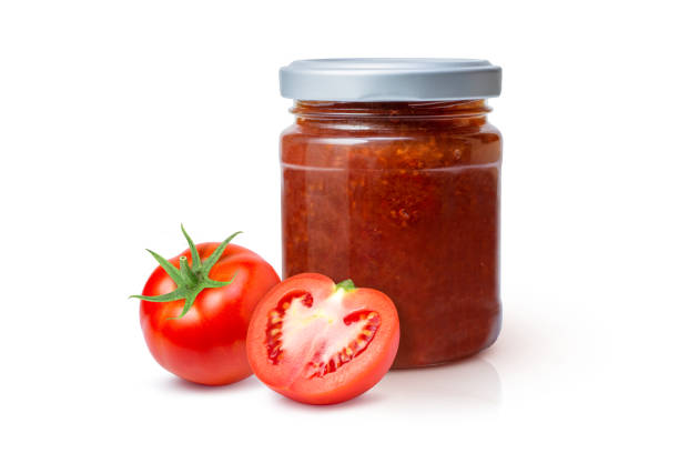 istock Tomato preserves jam in glass bottle with red tomatoes fruit 1330842132
