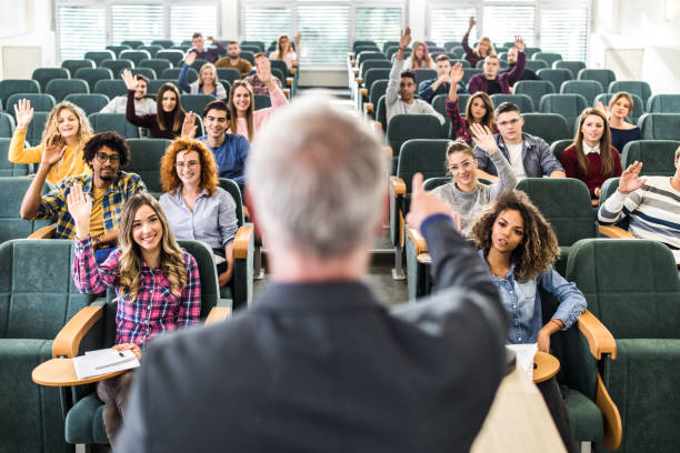 istock Happy college students raising their arms on a class at amphitheater. 1330843383