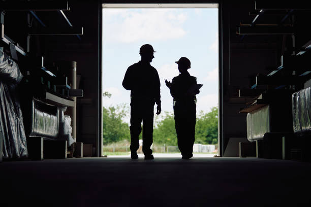 Silhouette of warehouse workers talking at storage compartment.