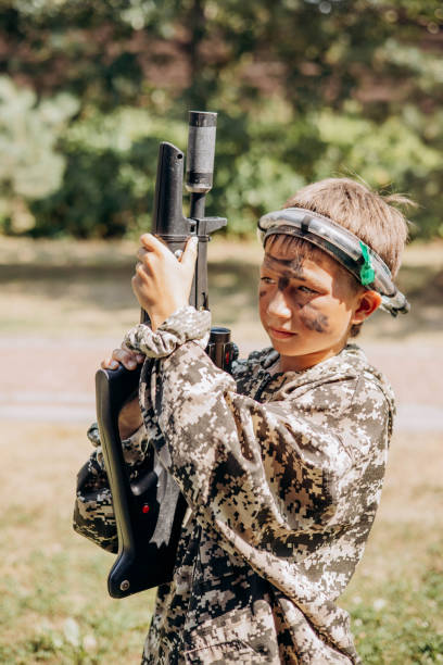 istock Boy with a weapon in his hand playing laser tag shooting game in outdoor. War simulation game 1330845954