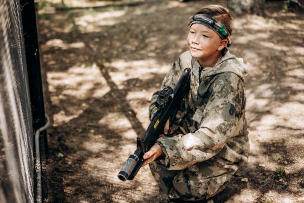 istock Boy with a weapon in his hand playing laser tag shooting game in outdoor. War simulation game 1330845985