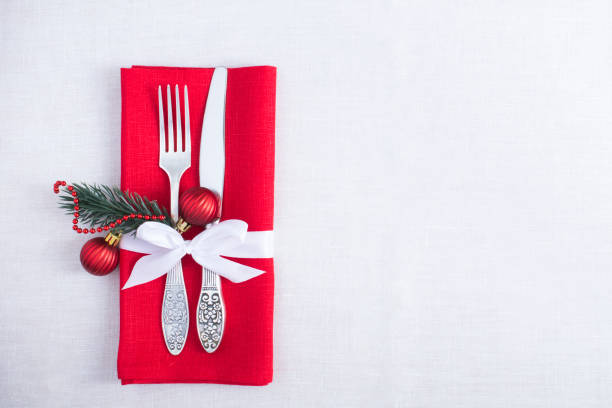 istock Christmas table setting with a red napkin on the white tablecloth. Top view. Copy space. 1330846104