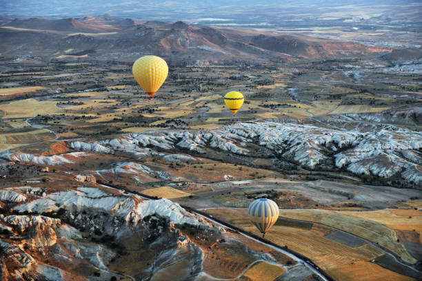 bunte heißluftballons fliegen über felslandschaft in kappadokien türkei - majestic awe canyon national park stock-fotos und bilder
