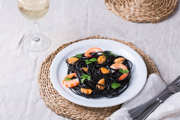 Black spaghetti pasta with seafood, shrimps, mussels and parsley stock photo