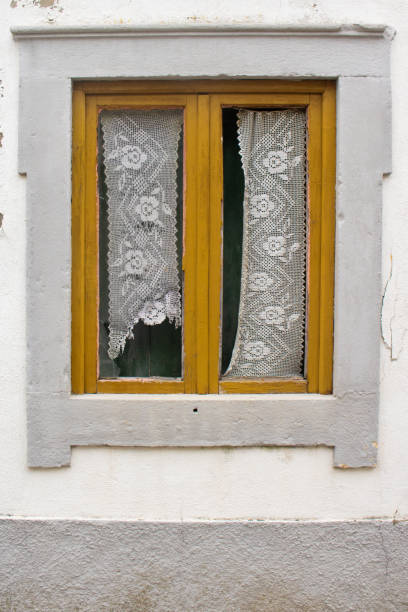 istock Broken window in abandoned rural house with yellow wooden frame 1330847788