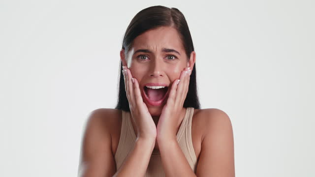 4k video footage of an attractive young woman looking scared against a studio background