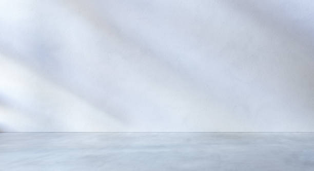 istock White textured wall and grey concrete floor as place for displaying your product. 1330849207
