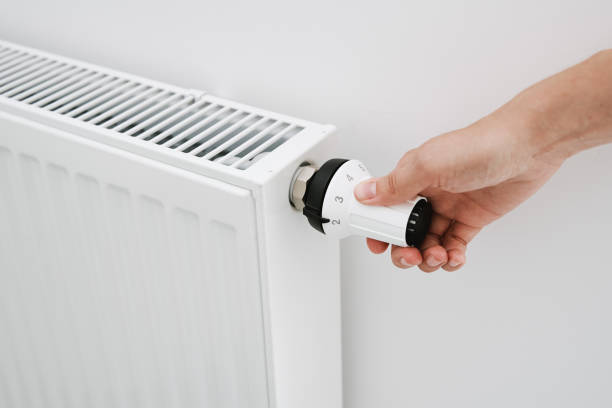 istock Woman hand adjusting temperature on heat radiator 1330850391