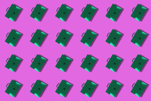 istock Green briefcases with handle on colored background. Closed plast 1330853029