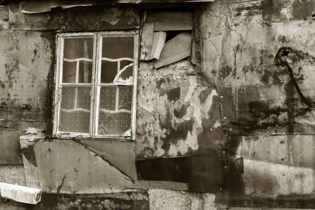 istock Broken window on wall of abandoned house 1330854611