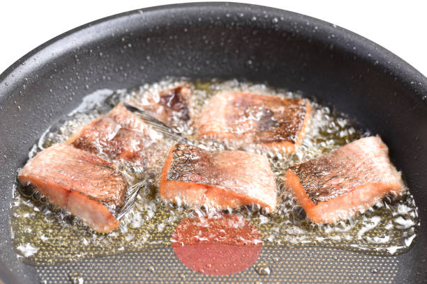 Sun-dried snakehead fish fried in a pan with vegetable oil