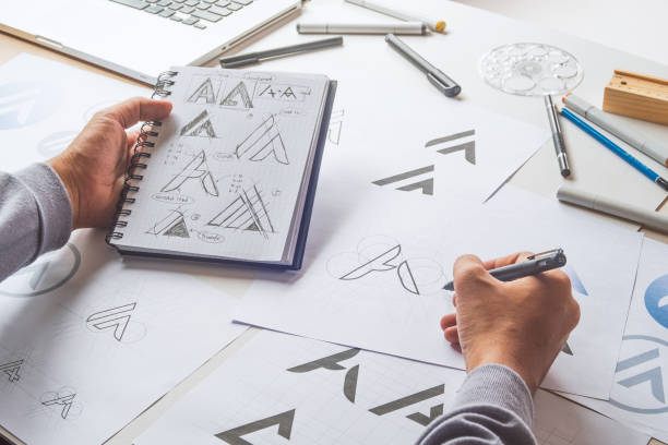 istock Graphic designer drawing sketch design creative Ideas draft Logo product trademark label brand artwork. Graphic designer studio Concept. 1330857651