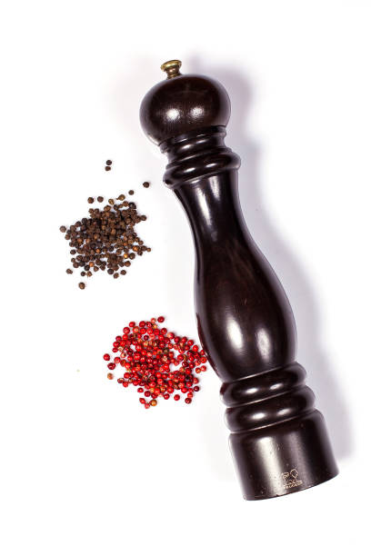 istock Pepper mill with black and red peppercorn isolated on white background 1330857870