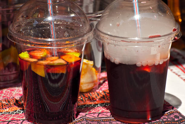 istock Multicolored fruit drinks close-up. Non-alcoholic drinks in plastic cups at the festival. Cocktails with juice and greens. White smoke is steaming with cocktails. 1330858906