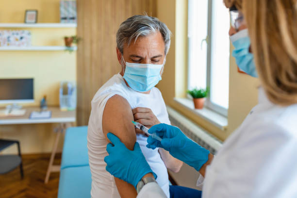 medical worker vaccinates a mature man in the arm in a medical office.medicine and healthcare concept.vaccination against coronavirus. - injecting flu virus cold and flu doctors office imagens e fotografias de stock