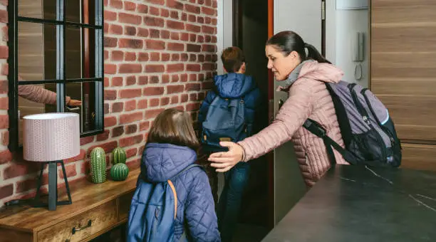 Family with emergency backpacks leaving their front door quickly due to an emergency evacuation