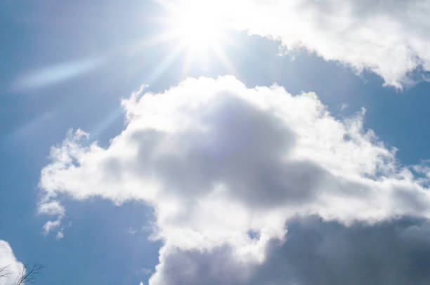 istock Sun came out from behind clouds.bright sun against blue sky with white-gray cloudy clouds, 1330862254