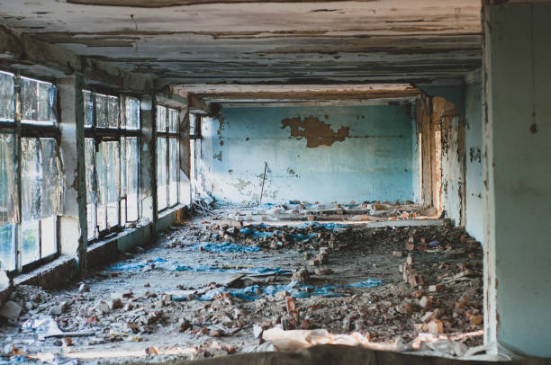 istock Old non-residential building from inside, peeling paint and fallen plaster with various construction debris on floor close-up 1330862394