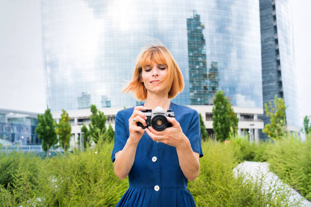 atractiva mujer pelirroja tomando fotos en la ciudad - high key portrait color image travel locations fotografías e imágenes de stock