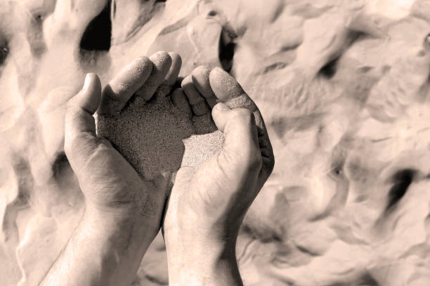 istock sand in mans hands. desert background 1330868095