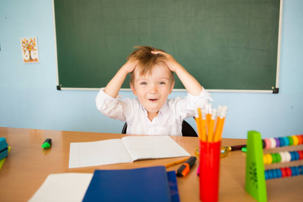 istock Back to school concept. Funny tired schoolboy ponders the difficult task 1330868183