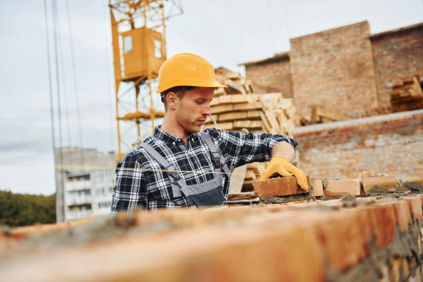 istock Laying bricks. Construction worker in uniform and safety equipment have job on building 1330871208