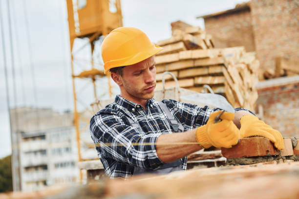 istock Laying bricks. Construction worker in uniform and safety equipment have job on building 1330871321