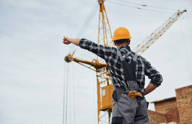 istock Communicates with the crane driver. Construction worker in uniform and safety equipment have job on building 1330872720