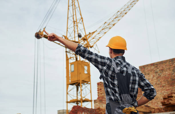 istock Communicates with the crane driver. Construction worker in uniform and safety equipment have job on building 1330872730