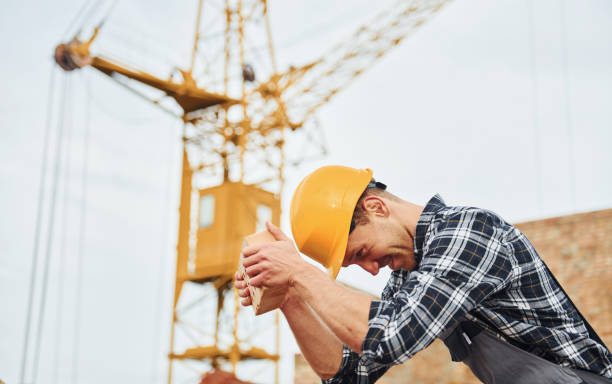 istock Having fun and testing hard hat by brick. Construction worker in uniform and safety equipment have job on building 1330872779