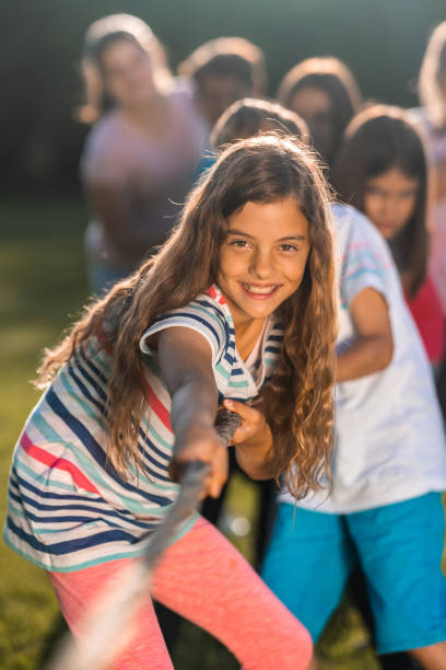 istock Group of children pulling a rope in public park 1330874778