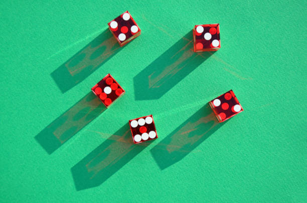 istock Red Casino or craps dice on green baize surface. Sunlit shadow 1330876265