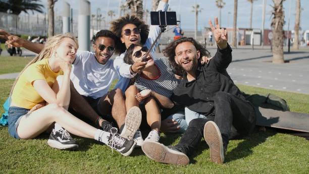 istock Laughing friends taking selfie on meadow 1330878408