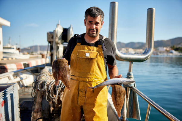 ritratto di pescatore indipendente che tiene catture fresche - fishermen harbor foto e immagini stock