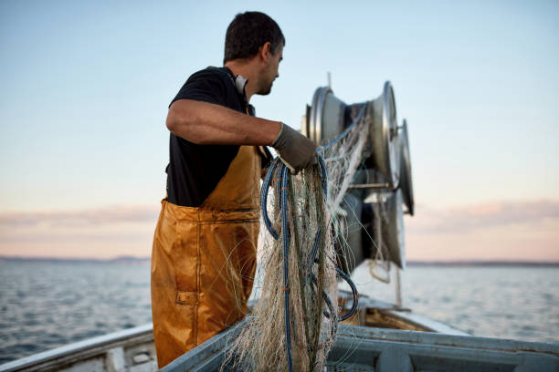 istock Commercial Fisherman Reeling Trawl Net with Winch 1330878511